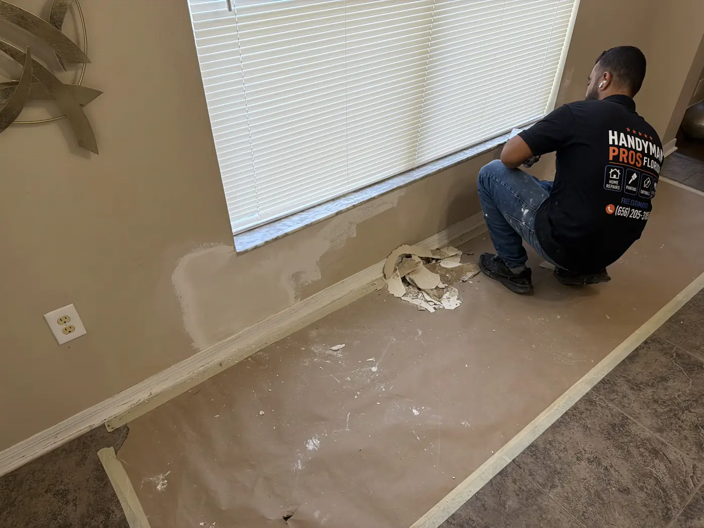 Handyman Pros Florida technician patching and finishing drywall under a window